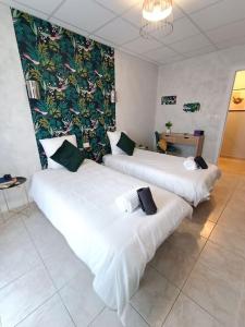 2 camas en una habitación de hotel con un mural en la pared en Le Savana Lodge, en Chanas