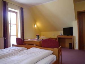 a hotel room with two beds and a table and a window at Da`Sporrer Hotel & Wirtshaus in Neunburg vorm Wald