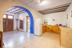 eine Küche mit einem weißen Kühlschrank und einem blauen Torbogen in der Unterkunft Casa Rural La Clau in Polop