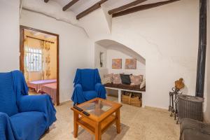 sala de estar con 2 sillas azules y mesa en Casa Rural La Clau, en Polop