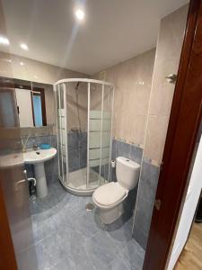 a bathroom with a toilet and a shower and a sink at Gijón Lauredal in Gijón