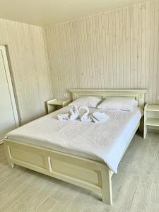 ein Schlafzimmer mit einem Bett mit zwei Handtüchern darauf in der Unterkunft VILLA DIANA in Solotwyno