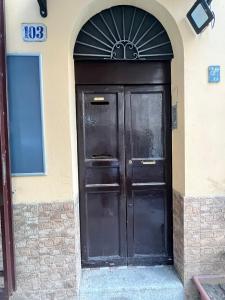 une grande porte noire sur le côté d'un bâtiment dans l'établissement House del corso, à Palerme