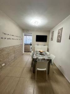 - un salon avec une table, des chaises et une télévision dans l'établissement House del corso, à Palerme