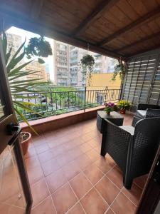 a balcony with chairs and a view of a city at House del corso in Palermo