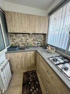 a kitchen with wooden cabinets and a sink and a stove at House del corso in Palermo
