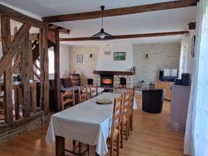 eine Küche und ein Wohnzimmer mit einem Tisch und einem Kamin in der Unterkunft Les Fortelles in Châtillon-sur-Broué