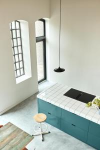 een keuken met een blauwe kast en een stoel bij Suvelfabryk in Lioessens