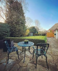 a patio with two chairs and a table in a yard at Burnley House Bed & Breakfast in Hutton le Hole