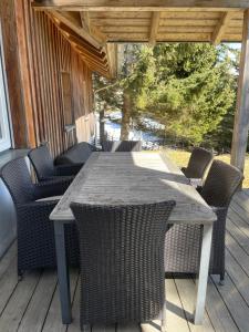 an outdoor table and chairs on a deck at Teichalm Lodge Landhaus in Fladnitz an der Teichalm