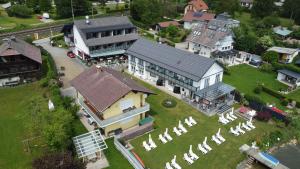 - une vue aérienne sur une grande maison avec une cour dans l'établissement Hotel Garni "Kärnten Inn" mit direktem Seezugang und E-Ladestation, à Bodensdorf