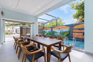 a dining room with a wooden table and chairs at Gia Nguyễn Villa Vũng Tàu in Vung Tau