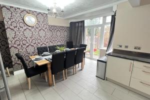 a dining room with a table and black chairs at Chelwood Residence in Moortown