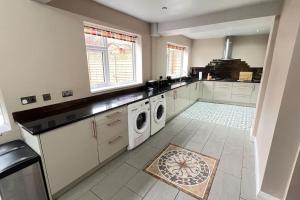 a kitchen with a washer and dryer in it at Chelwood Residence in Moortown