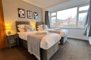 a bedroom with two beds and a large window at Chelwood Residence in Moortown