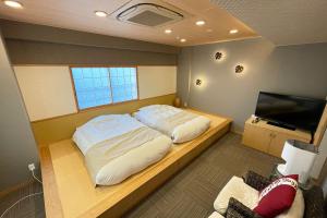 a bedroom with a bed and a flat screen tv at Ise-Shima Ohtaya Healing Stay in Toba