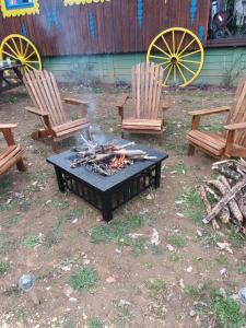 a fire pit in a yard with two chairs and benches at Git'an Périgord la Bonne aventure in Groléjac