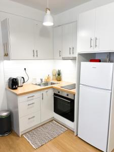 een keuken met witte kasten en een witte koelkast bij Comfy 2 BDR Apt in Petralona - Next to metro in Athene