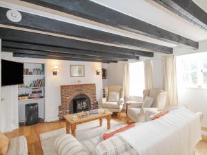 a living room with a couch and a fireplace at Vine Cottage in Studland