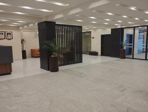 an empty lobby with potted plants in a building at Avari Xpress Gilgit in Gilgit