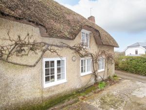 an old cottage with a thatched roof at Vine Cottage in Studland