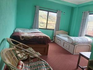a bedroom with two beds and a window at Tashidelek Guest Lodge & House in Dhulikhel