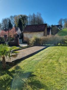 un patio con una casa y un campo de césped en La Ferme d'Antan Baie de Somme, en Mons-Boubert