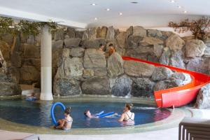 eine Gruppe von Personen in einem Pool in einem Wasserpark in der Unterkunft Alpenhotel Weitlanbrunn in Sillian