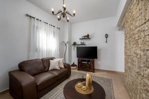un soggiorno con divano marrone e TV di Old Town Villa a Città di Rodi