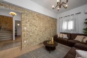 a living room with a couch and a stone wall at Old Town Villa in Rhodes Town