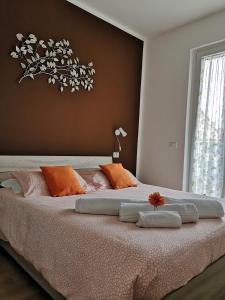 una camera da letto con un letto grande con cuscini arancioni e bianchi di My Home a Lazise