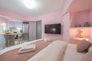 um quarto com uma cama grande e uma televisão na parede em The Courtyard Oasis em Atenas