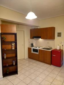 沃洛斯的住宿－Romance in Volos，厨房配有木制橱柜和红色冰箱。