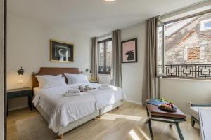 een slaapkamer met een groot wit bed en een raam bij Leonis Restaurant & Rooms in Split