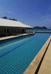 una piscina junto a un edificio y al océano en Thong Nai Pan Beach Resort en Thong Nai Pan Yai