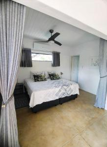 1 dormitorio con 1 cama y ventilador de techo en Giraffe Studio @ Kruger, en Marloth Park