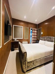a bedroom with a large bed and a couch at Cheshire Hotel Central London in London