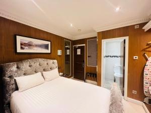 1 dormitorio con cama blanca y baño en Cheshire Hotel Central London en Londres