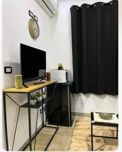 Cette chambre comprend un bureau avec un ordinateur et un four micro-ondes. dans l'établissement Appartement Cosy aux Jardins de Carthage, à Sidi Daoud