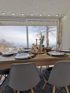 mesa de comedor con sillas y ventana grande en Casa Vrelo, Golija, en Raška