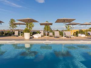 a swimming pool with umbrellas and chairs and a pool at Tenuta Cavalieri in Leverano