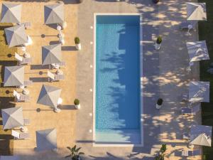 an overhead view of a swimming pool with tables and umbrellas at Tenuta Cavalieri in Leverano +2 photos