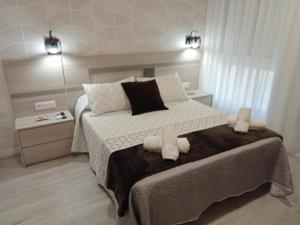 a bedroom with a large bed with two towels on it at Baixo a Lua Rooming in Sarria