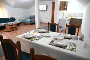 una mesa con platos en la sala de estar en Apartman Sena en Laktaši