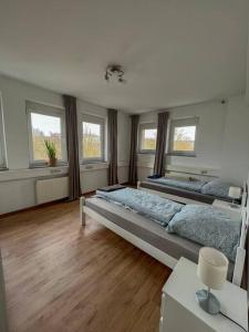 a large bedroom with two beds and windows at Modernes Apartment mit Balkon, Parkplatz und Smart Tv bis zu 10 Personen in Weinstadt