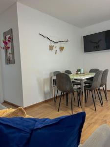 a dining room with a table and chairs at Modernes Apartment mit Balkon, Parkplatz und Smart Tv bis zu 10 Personen in Weinstadt