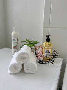 a bathroom counter with towels and a basket of soap at Modernes Apartment mit Balkon, Parkplatz und Smart Tv bis zu 10 Personen in Weinstadt