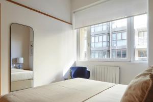 a bedroom with a mirror and a bed and a window at Eder 2 by FeelFree Rentals in San Sebasti&aacute;n