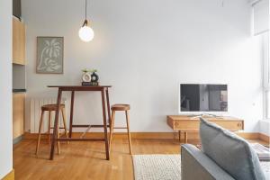 a living room with a table and a tv at Eder 2 by FeelFree Rentals in San Sebasti&aacute;n