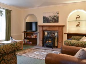 a living room with a fireplace and a tv at Barnscliff Heights in Broxa